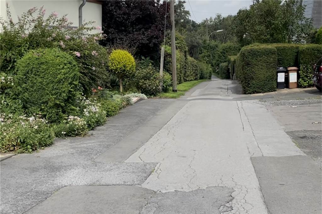 Streit um Straßenreinigung: Anlieger müssen nach über 30 Jahren zahlen Die Straße ist sehr schmal, hat keinen Bürgersteig, dafür aber etliche Ausbesserungen und Schlaglöcher.