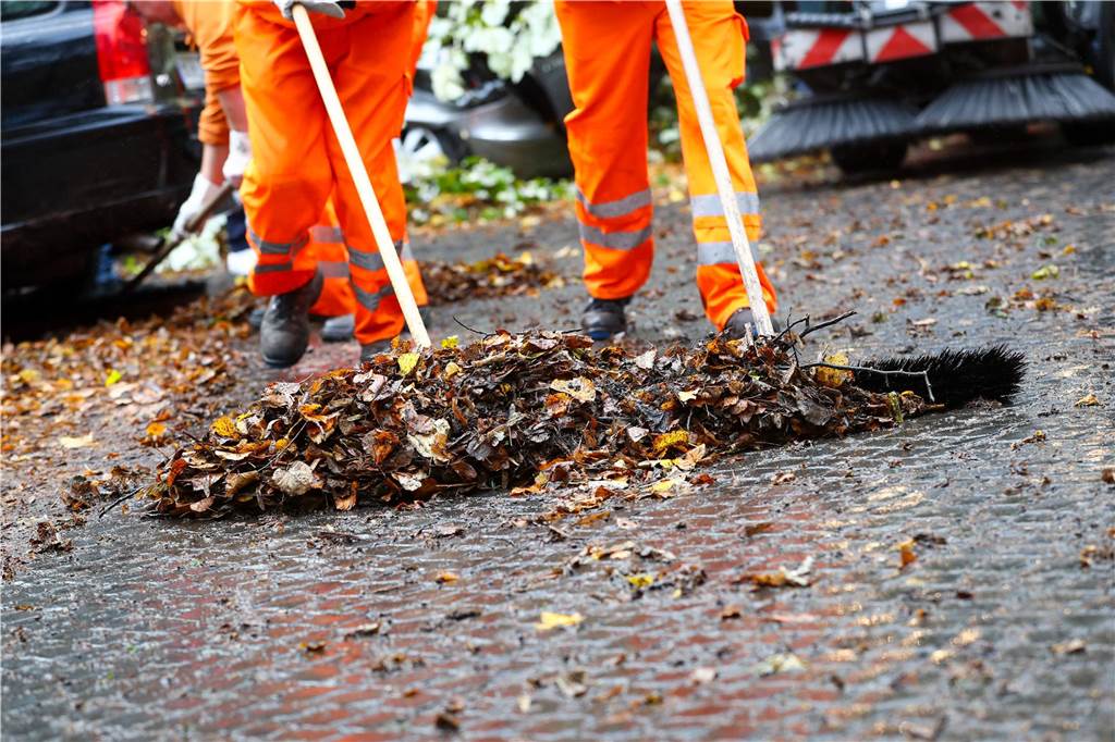 Gebühren: Südlohner müssen ab 2025 tiefer in die Tasche greifen Menschen, die Laub beseitigen.