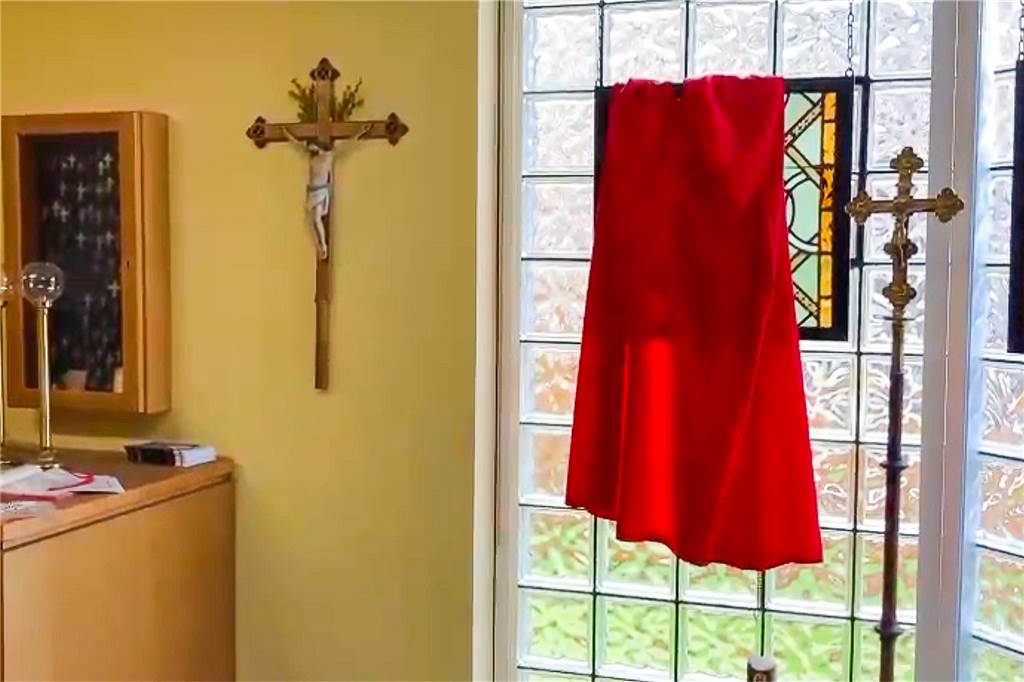Safe in Kirche aufgebrochen: Einbrecher verwüsten Sakristei Messdienergewand hängt vor einer Scheibe
