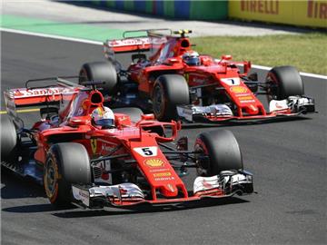 Die Teamkollegen Sebastian Vettel (l) und Kimi Räikkönen vom Team Scuderia Ferrari starten an Eins und Zwei. Foto: Zsolt Czegledi