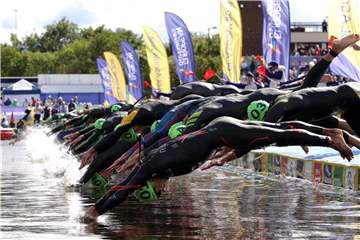 Die Teilnehmer des Männer-Triathlons springen ins Wasser. Jonas Schomburg beendet den Wettbewerb als Zehnter. Foto: John Walton/PA Wire