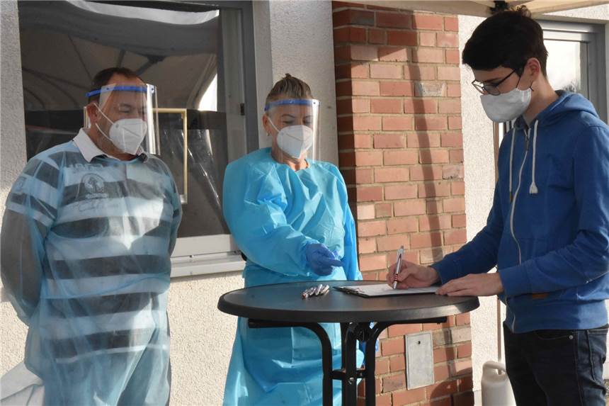 Rotes Kreuz bietet in vielen Orten Corona-Schnelltest vor Weihnachten an Die Tests in Borken laufen bereits: Johann Wolter füllt den Meldebogen aus, im Hintergrund Carsten Dinkelborg und Judith Bremer.