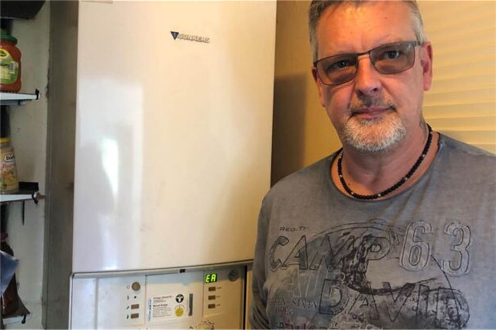 Mieter Jörg Jensen steht vor seiner Warmwasser-Therme.