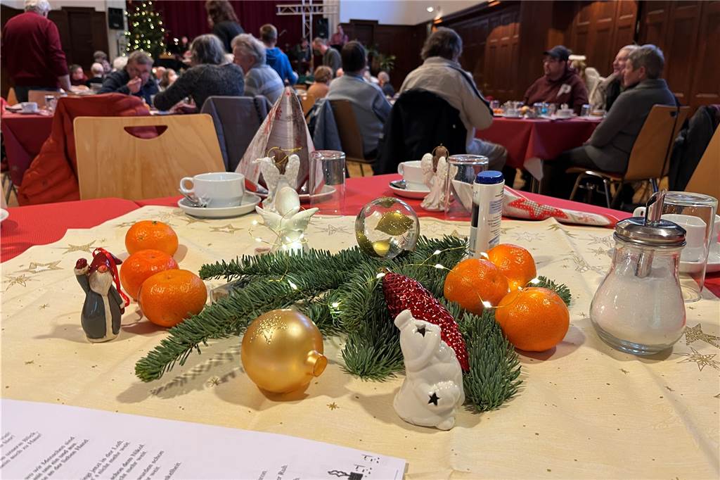 Die Tische im Wichernhaus bei der Weihnachtsfeier 2022 wurden liebevoll mit Tannenzweigen und Mandarinen geschmückt. 