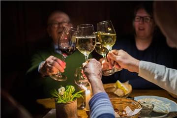 Die Tischgruppe, die hier gemeinsam anstößt, hat sich in der Weinstube „Hottum“ zufällig zusammen gefunden. Foto: Andreas Arnold