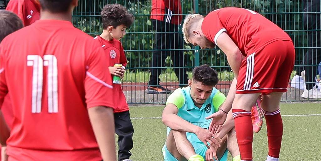 Ein Spieler von Eving Sport sitzt nach dem Schlusspfiff traurig auf dem Rasen.