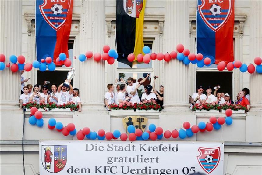 Uerdingen plant für 3. Liga - Waldhof sieht Ungereimtheiten Die Uerdinger Mannschaft feiert mit dem Meisterpokal der Regionalliga West am Rathaus den Aufstieg in die 3. Liga. Foto: R. Weihrauch