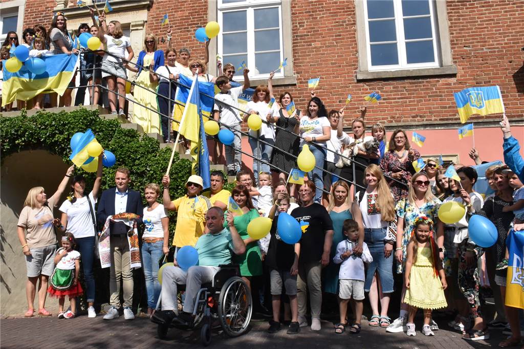 Zuflucht in Vreden: Olena Bezhanska (28) floh vor den Bomben in der Ukraine Die Ukrainerinnen und Ukrainer feierten ihren Nationalfeiertag am Vredener Rathaus. Olena Bezhanska – im traditionellen weißen Oberteil und Jeansrock – war auch dabei. (Unten rechts im Bild)