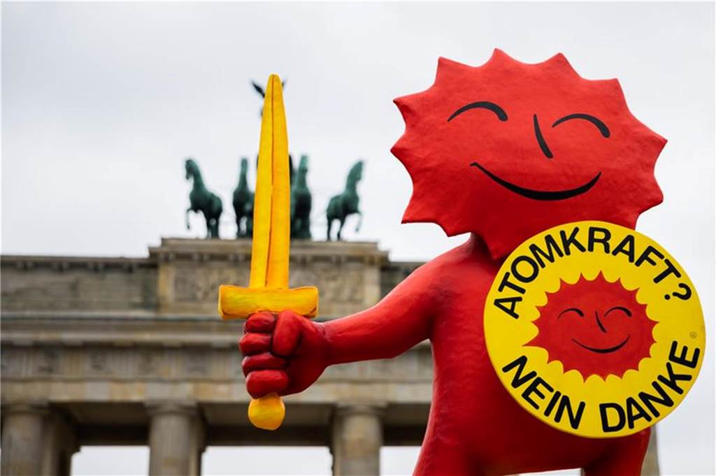 Ende der Atomkraft in Deutschland: „Der Atomausstieg macht Deutschland sicherer“ Figur mit "Atomkraft? Nein Danke" Schild vor dem Brandenburger Tor.