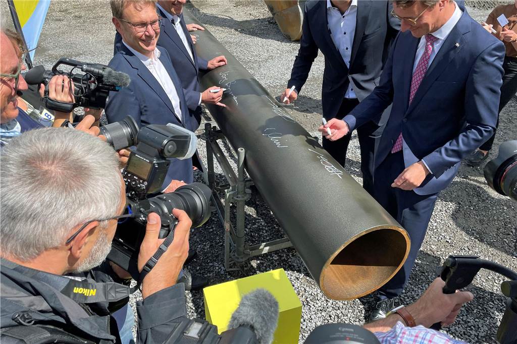 Die Verantwortlichen setzten unter großer Medienbeteiligung ihre Unterschriften auf das Rohr als symbolischen Start der Bauarbeiten.