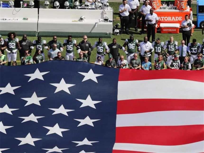Hymnen-Protest im US-Sport - NBA-Coach: "Problem bleibt" Die Verfplichtung der Sportler bei der Nationalhymne zu stehen erfüllen die Spieler der New York Jets, bilden aber als Zeichen des Protests eingehakt eine Kette. Foto: Frank Franklin II