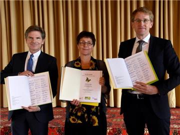 Die Verhandlungsführer der schleswig-holsteinischen Koalitionsverhandlungen, (l-r) Heiner Garg (FDP), Monika Heinold (Bündnis 90/Die Grünen) und Daniel Günther (CDU), zeigen in Kiel den Koaltionsvertrag. Foto: Carsten Rehder