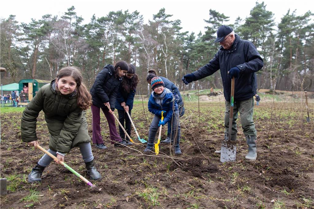 Pflanzaktion: 200.000 Bäume für Kirchhellen und den Klimaschutz Die Viertklässler der Cyriakusschule lassen sich beim Baumpflanzen von den ehrenamtlichen Helfern anleiten.
