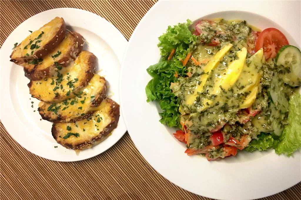 Im Olafs serviert Olaf frische Salate und feine Burger Die Vorspeise: das überbackene Knoblauchbrot und der vegetarische Salat.