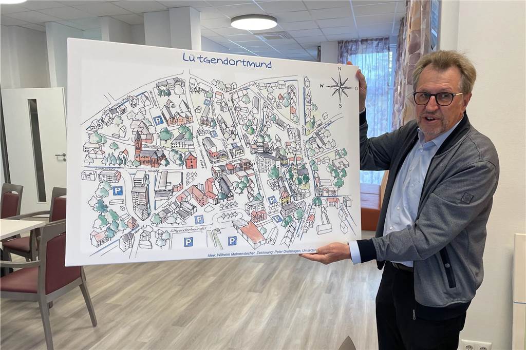 Die Wände des neuen Seniorenwohnsitzes sind hier und da auch noch kahl. Lothar Heinze zeigt ein Lütgendortmund-Bild, das das Treppenhaus schmücken wird.