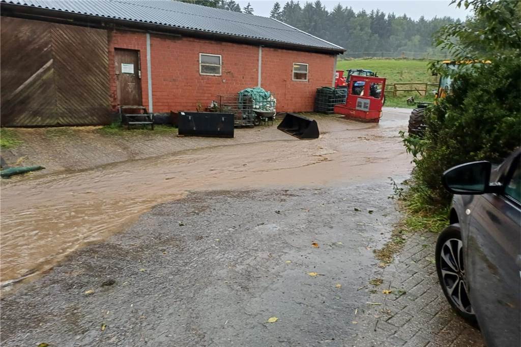 Feuerwehr war nach Unwetter am Abend im Dauereinsatz Eine teilweise überflutete Straße vor einem Backsteinhaus