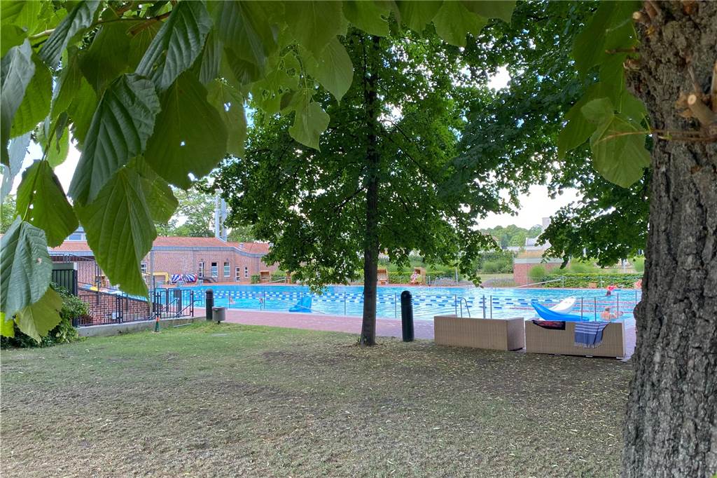 Die Wiese wird nur von der Tribüne vom Freibad-Becken getrennt.