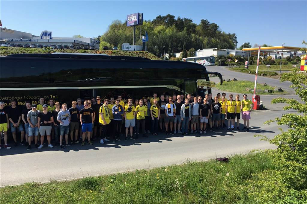 „Young Generation“: Wie das Fanprojekt Dortmund den BVB für Jugendliche erlebbar macht Jugendliche BVB-Fans posieren vor einem Bus.