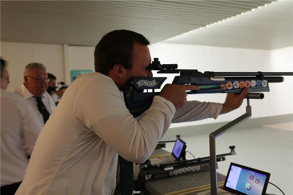 Mann schießt mit Luftgewehr