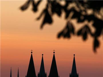 Die zwei Türme der Johanniskirche (L) und die vier Türme des Domes in Würzburg im Sonnenaufgang. Foto: Karl-Josef Hildenbrand