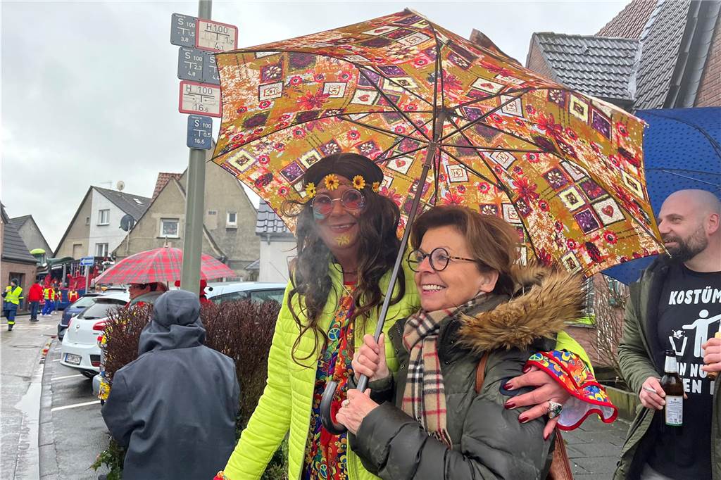 Diese beiden Zuschauerinnen warten am Straßenrand auf das Vorbeiziehen des Zuges.