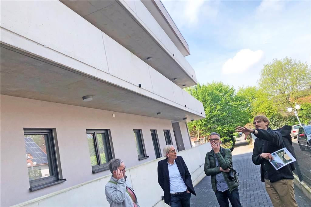 Südlohn anders sehen: Ortsrundgang mit Stadtplanern sensibilisiert Teilnehmer des Ortsrundgangs vor einer Betonfassade