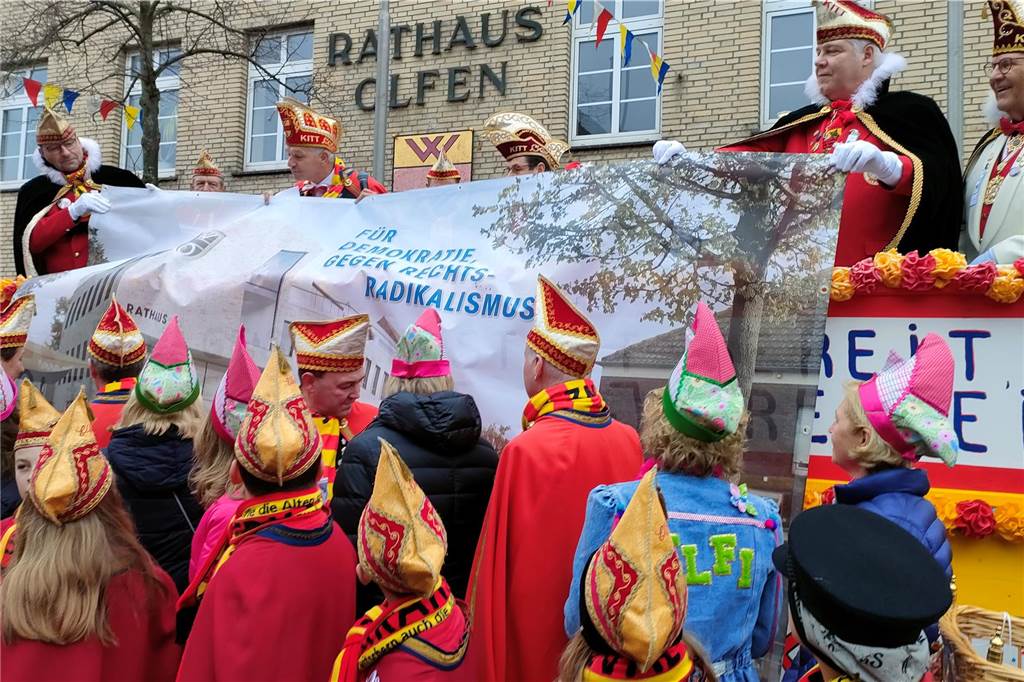 Schlüsselübergabe: Narren fordern ganzjährig Nelkendienstagsumzüge Dieses Banner mit der Aufschrift "Für Demokratie - Gegen Rechtsradikalismus" hängt künftig am Bauzaun des Rathaus-Neubaus.