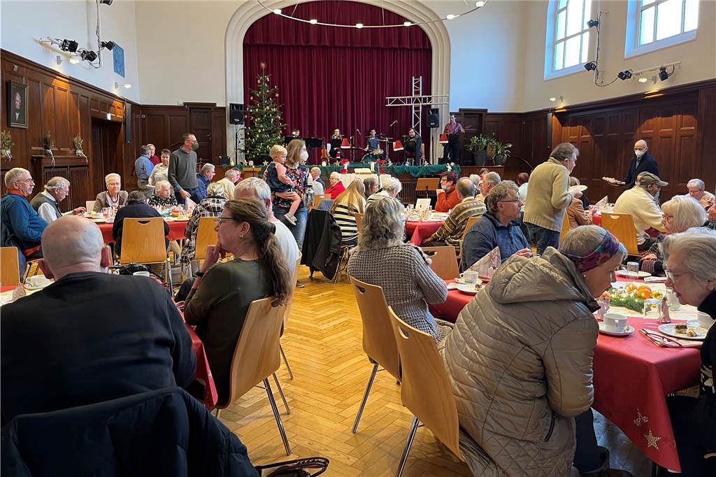 Menschen sitzen an Weihnachten 2022 an Tischen im Wichernhaus und feiern den Heiligen Abend. 