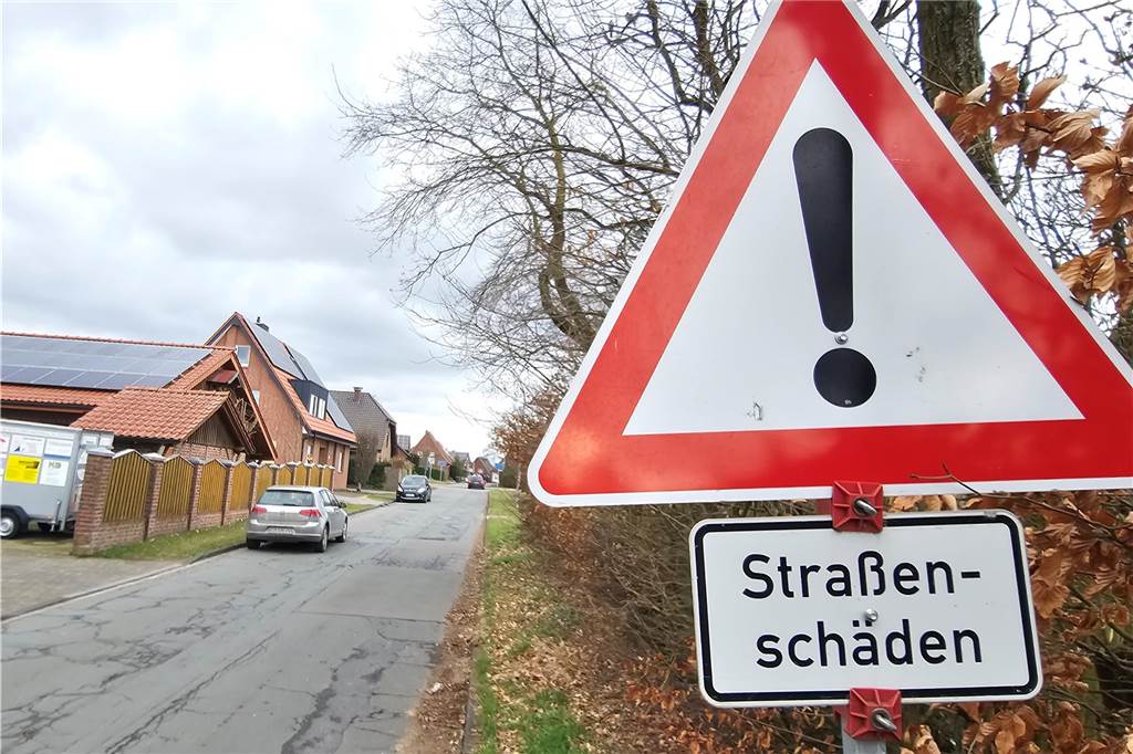 Sanierung Bischof-Hermann Straße: Müssen die Anlieger dafür zahlen? Ein Straßenschild weist auf Straßenschäden hin