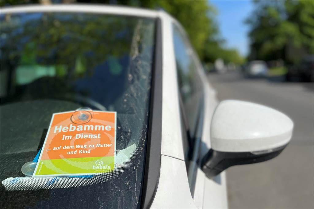 Nach spontaner Hausgeburt: Hebamme erhält Strafzettel wegen Falschparkens Dieses Schild mit der Aufschrift "Hebamme im Dienst" hat Laura Eßmann an der Frontscheibe ihres Autos befestigt.