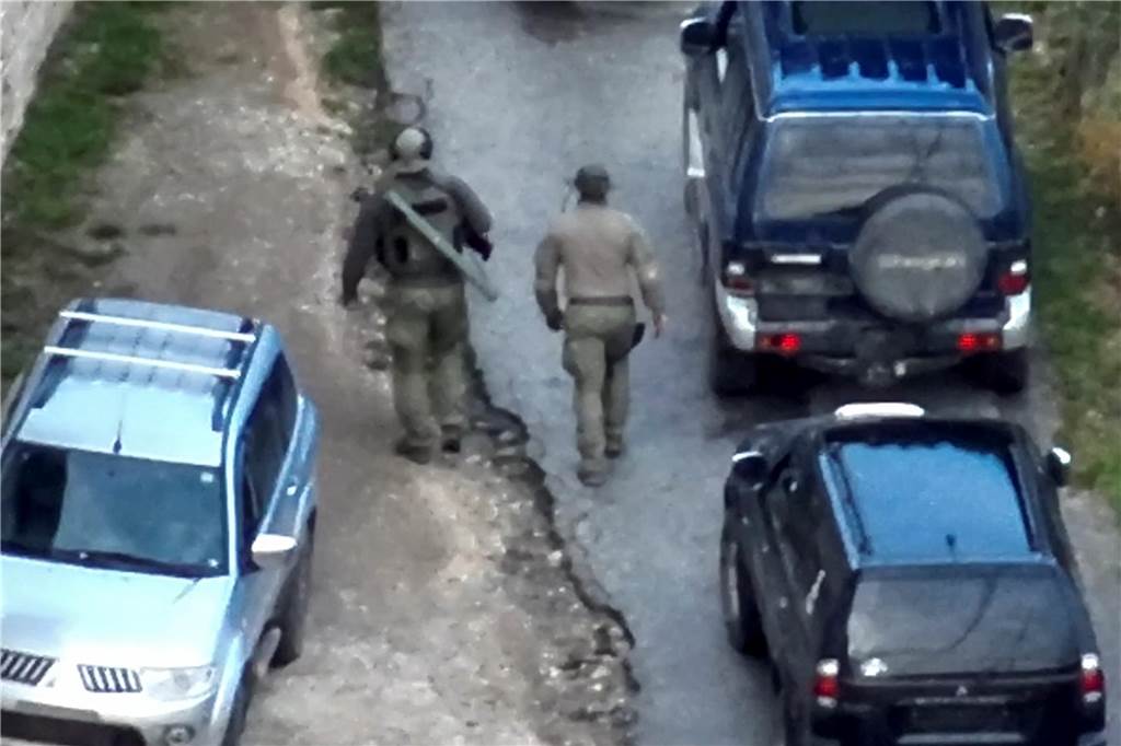 Schwere Kämpfe im Nord-Kosovo: Serbisches Paramilitär zerschlagen – Westen ruft zu Dialog auf Dieses von der Kosovo-Polizei zur Verfügung gestellte Bild zeigt zwei bewaffnete, maskierter Männer vor dem Banjska-Kloster. In dem fast ausschließlich von Serben bewohnten Norden des Kosovos ist eine militärisch ausgerüstete Kampftruppe eingedrungen.