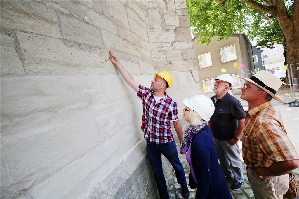 Versprochen: Unnas Stadtkirche wird wieder heil Dietrich Schneider vom Kirchenkreis erklärt den Besuchern die Schäden an der Außenfassade.