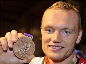Dimitri Peters posiert im Deutschen Haus mit seiner Bronzemedaille. Foto: Marius Becker