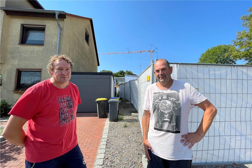 Kampf gegen Schul-Anbau in Dortmund geht weiter: „Immer noch total wütend“ Matthias Sprenger (l.) und Ernst Kaaf vor dem Baustellenzaun, hinter dem der Anbau der Hansa-Grundschule entstehen wird.