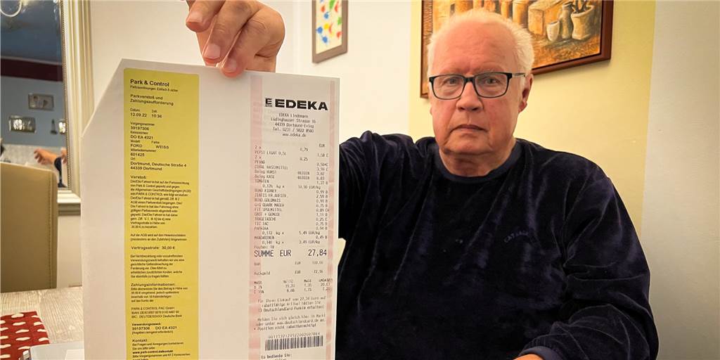 Ein Mann aus Dortmund hält einen bedruckten Zettel in der Hand.