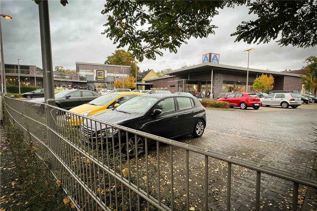 Ein Parkplatz mit Supermärkten im Hintergrund