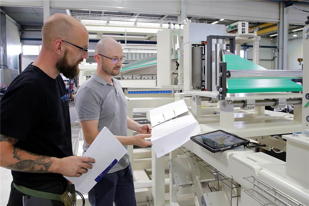 Spezialmaschinen aus Haltern: Firma GFM ist Weltmarktführer Zwei Männer schauen vor einer Maschine in Pläne.