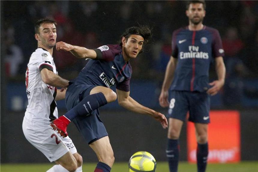 Frankreichs Meister Paris nur 2:2 gegen Guingamp Doppeltorschütze Edinson Cavani (M) von Paris St. Germain im Zweikampf mit Guingamps Christophe Kerbrat (l). Foto: Thibault Camus/AP