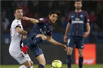 Doppeltorschütze Edinson Cavani (M) von Paris St. Germain im Zweikampf mit Guingamps Christophe Kerbrat (l). Foto: Thibault Camus/AP