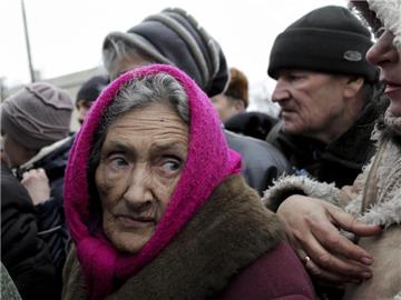 Dorfbewohner der umkämpften Region um Luhansk stehen an einer Ausgabestelle für Hilfsgüter Schlange. Foto: Anastasia Vlasova
