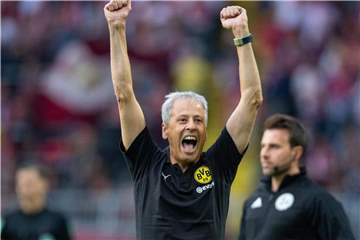 Dortmunds Trainer Lucien Favre jubelt nach dem Tor zum 4:1 und reißt die Arme in die Luft. Foto: Guido Kirchner/aktuell