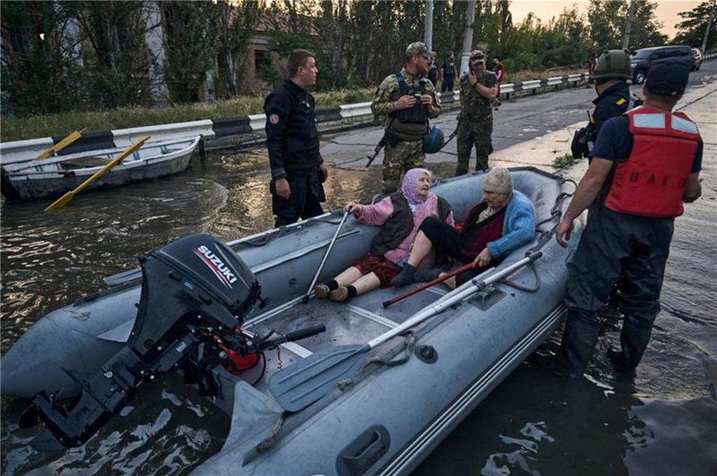 dpatopbilder - Viertel von Cherson stehen unter Wasser. Rettungskräfte evakuieren Bewohnerinnen mit Booten. Foto: Libkos/AP/dpa
