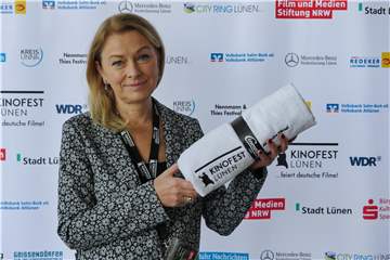 Dr. Anke Höwing, Mitglied des Ehrenrats des Kinofests, mit dem Badehandtuch des Festrivals, das sie als „Darstellerin“ des Films „Fabian“ bekommen hat.