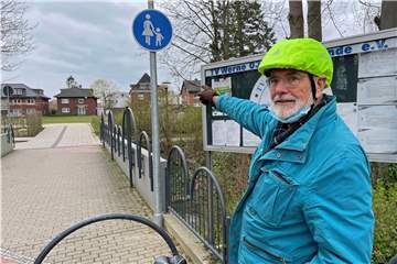 Ein Mann zeigt auf ein Schild am Solebad Werne.