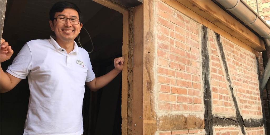 Altstadt Werne: Neuer Eigentümer erklärt im Video Pläne für zwei historische Gebäude Dr. med. Nurjan Satimov schaut aus dem Fenster des alten Fachwerkhauses neben der ehemaligen Spielhalle.
