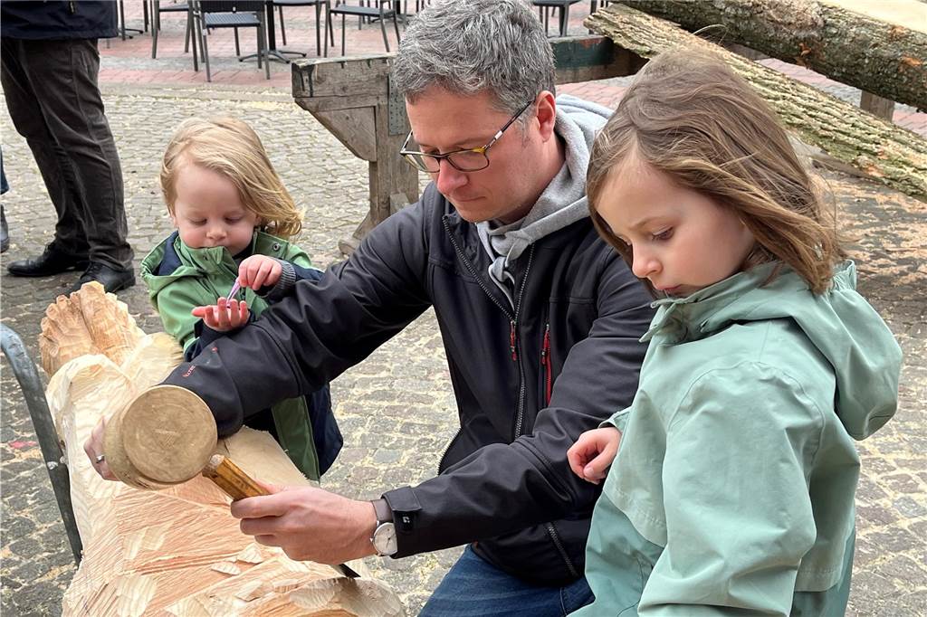 Vater schnitzt mit seinen Kindern.
