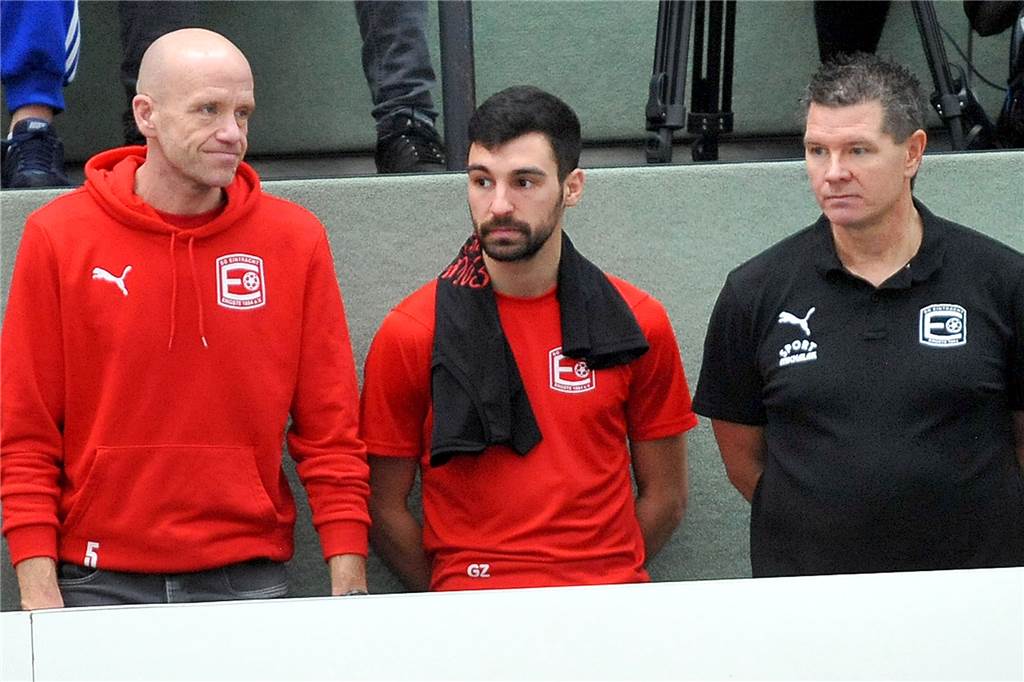 Drei Ergster hinter der Bande (v.li.) Andreas Schang (Sportlicher Leiter) sowie das Trainergespann der ersten Mannschaft, Gianluca Zocco und Christian Tarrach.
