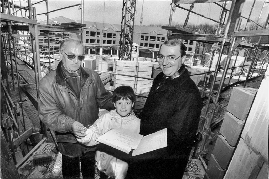 Buch zu 100 Jahren Schettler: Chef gibt Versprechen trotz Baukrise Schwarz-weiß-Foto von zwei Männern und einem Jungen auf einer Großbaustelle.