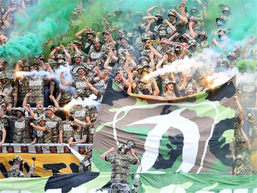Nach Fan-Ausschreitungen: Harte Strafen für Dynamo Dresdner Fans in Tarnkleidung zünden zu Spielbeginn beim Karlsruher SC bengalisches Feuer auf der Tribüne. Foto: Uwe Anspach