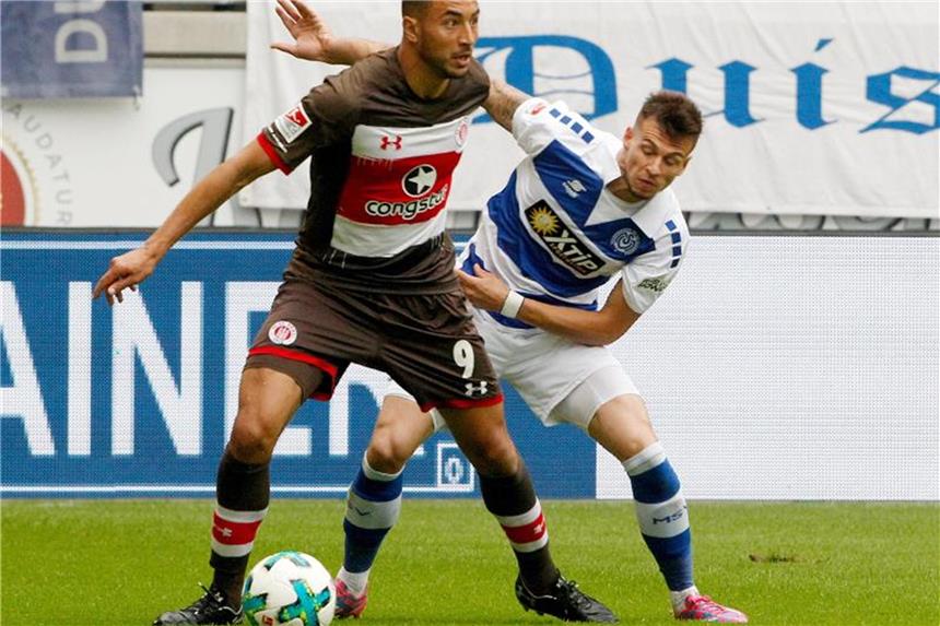 Duisburg klettert auf Rang sieben: 2:0 über St. Pauli Duisburgs Fabian Schnellhardt (r) und St. Paulis Aziz Bouhaddouz kämpfen um den Ball. Foto: Roland Weihrauch